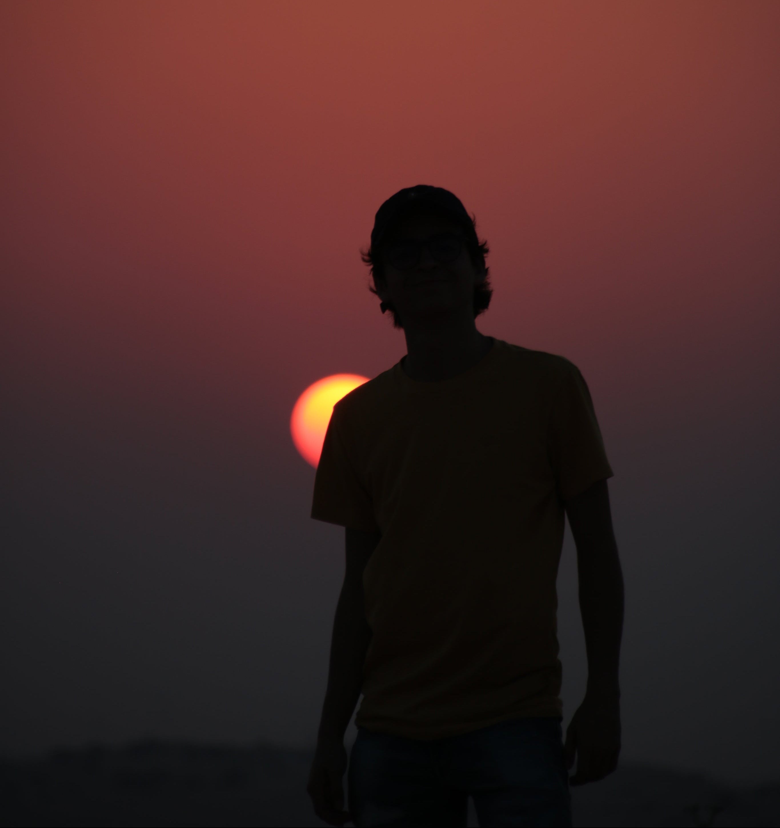 silhouette-of-a-person-with-a-baseball-cap-against-a-setting-sun.jpg